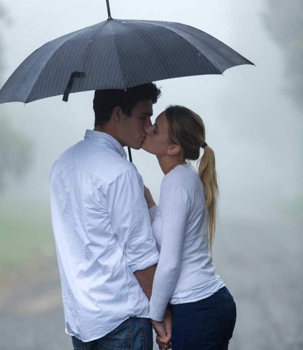 Парень и девушка держатся зонт