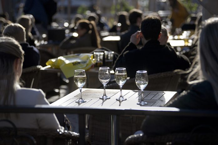 People enjoy the sun in an outdoor restaurant in Stockholm