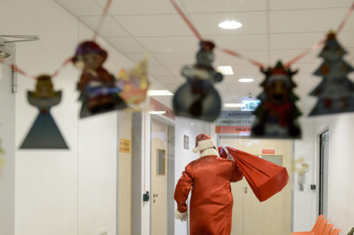 A firefighter dressed as Santa Claus visits the children's ward at Markhot Ferenc Hospital in Hungary